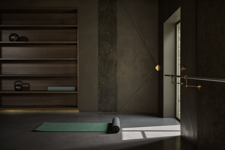 Regal mit Kettlebell, Faszienrolle und gefalteter Trainingsmatte in einem minimalistischen Trainingsraum
